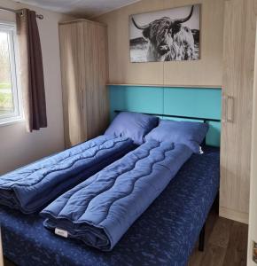 a large bed in a bedroom with a bull on the wall at CS 9 - Vakantiepark Callassande in Callantsoog