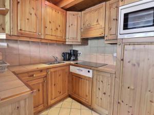 - une cuisine avec des placards en bois et un four micro-ondes dans l'établissement Appartement Méribel, 2 pièces, 6 personnes - FR-1-182-154, à Méribel