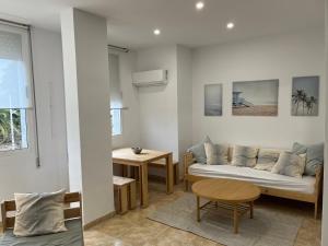 uma sala de estar com um sofá e uma mesa em Bet&CoBeach Apartments em Valência
