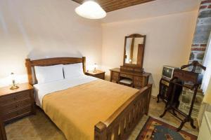 a bedroom with a large bed and a mirror at Villa Kastanodasos in Emporio