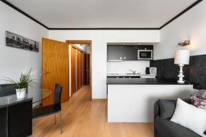 a kitchen and living room with a table and a couch at Apartamento Portugal in Quarteira