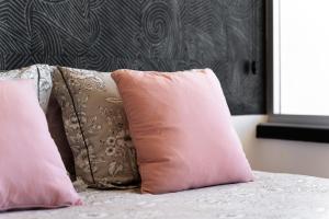 two pink pillows sitting on top of a bed at Apartamento Portugal in Quarteira