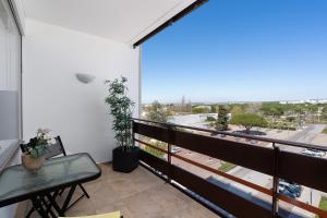 a balcony with a table and a view of a street at Apartamento Portugal in Quarteira