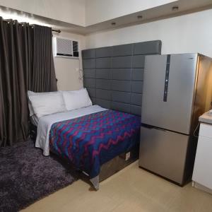 a small room with a bed and a refrigerator at Avida Davao Condos, downtown CM Recto Avenue, Davao City in Davao City