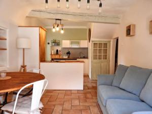 a living room with a blue couch and a table at Luberon maison au cœur d'un village provençal in Saint-Saturnin-les-Apt