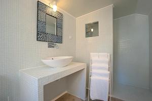 een witte badkamer met een wastafel en een spiegel bij Portas do Teatro Apartments in Lissabon +20 foto's