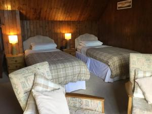 ein Hotelzimmer mit 2 Betten und einem Sofa in der Unterkunft Westward Bed and Breakfast in Cannich