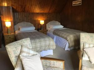 a hotel room with two beds and a couch at Westward Bed and Breakfast in Cannich