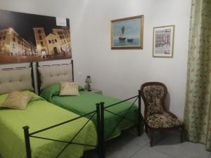 1 Schlafzimmer mit 2 Einzelbetten und einem Stuhl in der Unterkunft Tuttoincentro in Salerno