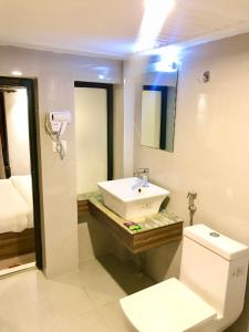 Shiva Guest House في بهاكتابور: حمام أبيض مع حوض ومرحاض