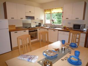 een keuken met een tafel met blauwe gerechten erop bij Innisfallen Holiday Homes in Killarney