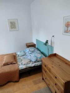 a bedroom with a bed and a wooden dresser at sudety hut 3 in Podgórzyn