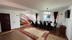 a living room with a dining room table and chairs at Pensiunea Miruna Slănic Moldova in Slănic-Moldova