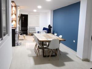 a dining room with a table and white chairs at Hermoso y amplio apartamento con garaje en San Gil in San Gil