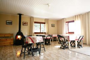 a dining room with tables and chairs and a fireplace at Cânions de Cambará in Cambará