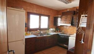 a kitchen with a white refrigerator and a sink at 6 persoons bungalow met gemeenschapelijk zwembad in Benitachell