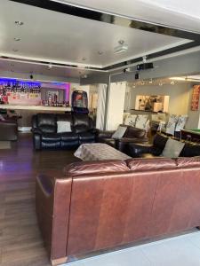 a large living room with leather couches and a bar at The Woodfield Hotel in Blackpool
