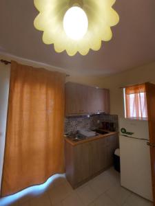 a kitchen with a ceiling light and a refrigerator at Amaryllis Hotel in Karpathos