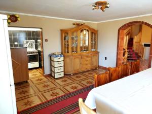 a room with a kitchen with wooden cabinets and a table at Casa Neagu in Covasna