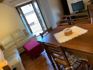 sala de estar con mesa y sofá en La Casa degli Archi, en Montepulciano