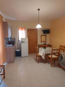 a kitchen with a table and a white refrigerator at Amaryllis Hotel in Karpathos
