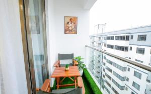 a balcony with a table and a chair on it at COZY 3-BEDROOM SERVICED APARTMENT IN LAVINGTON BY COZY HOMEs in Nairobi