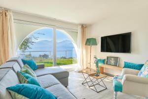 a living room with a couch and a large window at Villa Paier Relais & Pool in Malcesine