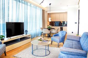 a living room with a blue couch and a tv at Katamare Hotel in Budva