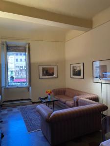 a living room with couches and a table and a window at Nobil Dimora Ancilli in Siena