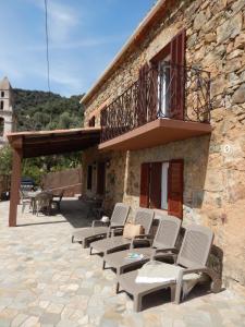 a group of chairs sitting outside of a building at Maison de village située dans le magnifique Golfe de Porto in Osani