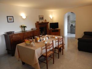 een eetkamer met een tafel en een bank bij Maison de village située dans le magnifique Golfe de Porto in Osani