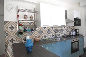 una cucina con armadi blu e un vaso blu su un bancone di Villa Schiaffino Appartamento al Primo Piano a Deiva Marina