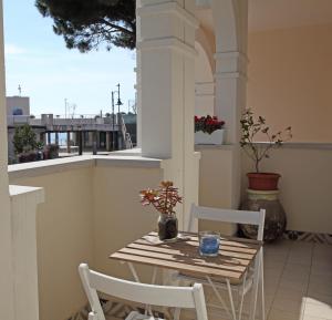 un tavolo e sedie su un balcone con finestra di Villa Schiaffino Appartamento al Primo Piano a Deiva Marina