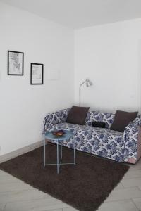- un salon avec un canapé bleu et une table dans l'établissement Villa Schiaffino Appartamento al Primo Piano, à Deiva Marina