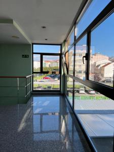Habitación con ventanas y vistas a la ciudad. en Hotel Chips Ferrol, en Narón