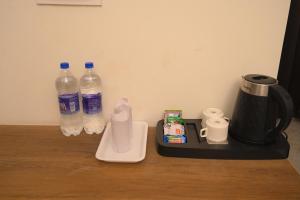 a counter with a coffee maker and two bottles of water at The Govindam Resort in Vrindāvan