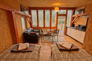 Zimmer mit 2 Betten und einem Tisch in einer Hütte in der Unterkunft Caledonian Glamping in Cannich