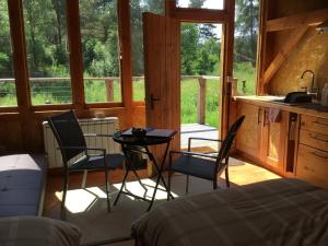 a bedroom with a bed and a table and chairs at Caledonian Glamping in Cannich