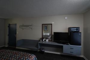 a hotel room with a television and a bed at Economy Inn Historic District in Saint Augustine
