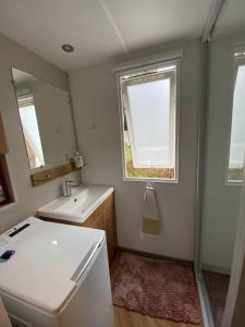 a small bathroom with a sink and a mirror at Neuf 2022, 6-8 personnes, piscine, vacancesdenani in Saint-Julien-en-Born