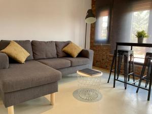 - un salon avec un canapé et une table dans l'établissement Suites La Catedral, à León