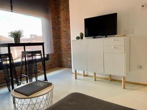 a living room with a white cabinet with a tv on it at Suites La Catedral in León