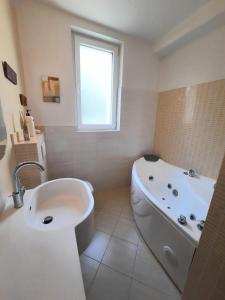 a white bathroom with a tub and a sink at MORABEZA Opatija in Opatija