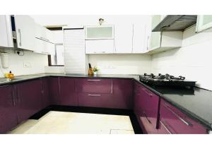a kitchen with white cabinets and purple counters at BluO 2BHK - M Block Balcony, Parking , Lift in New Delhi