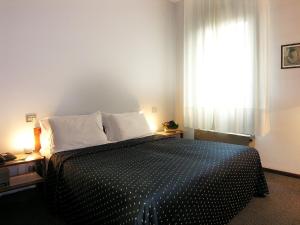 a bedroom with a black and white bed with a window at Hotel Al Cason in Padova