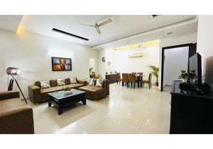 Una sala de estar con sofás y un comedor. en BluO 2BHK - Greater Kailash Lift Balcony Parking, en Nueva Delhi