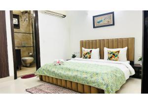 Un dormitorio con una cama grande y un baño. en BluO 2BHK - Greater Kailash Lift Balcony Parking, en Nueva Delhi 5 fotos más