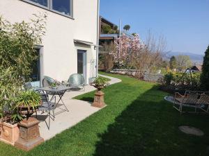 um pátio com uma mesa e cadeiras num quintal em Schöne Wohnung mit Ausblick und Gartensitzplatz em Lörrach