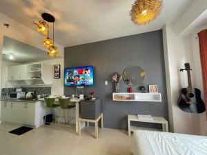 Zimmer mit einer Küche und einem Schlafzimmer mit einem Tisch in der Unterkunft Cool Suites at Wind Residences Tagaytay Staycation- IM HANA 1 in Tagaytay