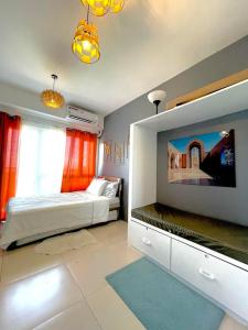Schlafzimmer mit einem Bett und einem Flachbild-TV in der Unterkunft Cool Suites at Wind Residences Tagaytay Staycation- IM HANA 1 in Tagaytay